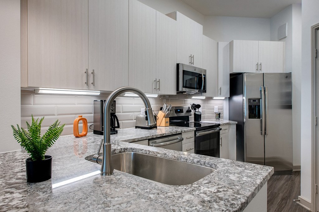 a kitchen with granite counter tops and stainless steel appliances