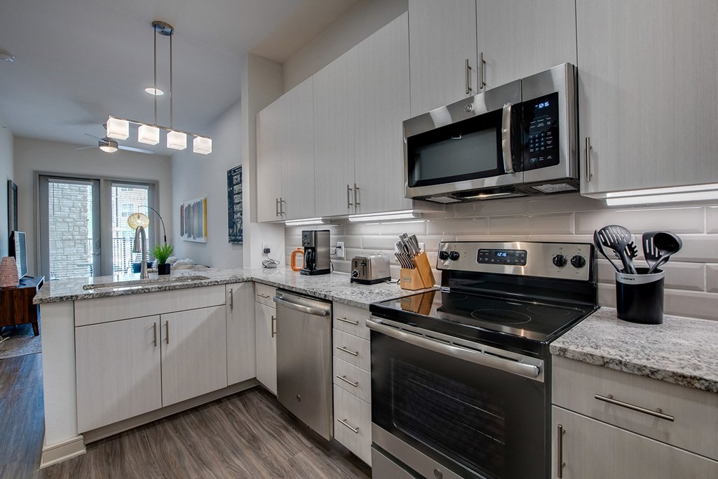 a kitchen with stainless steel appliances and white cabinets