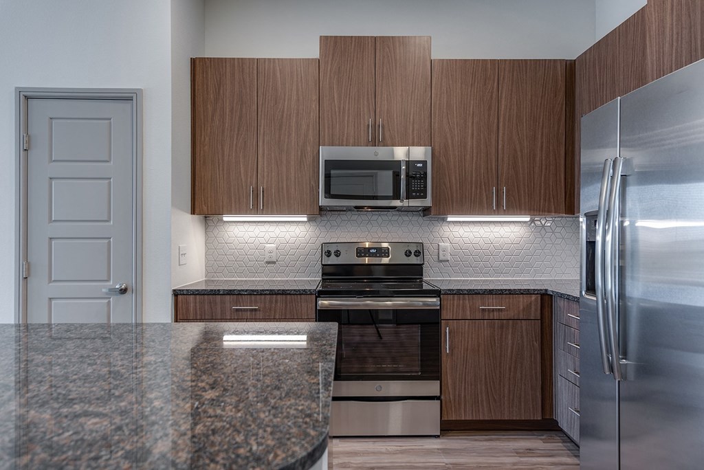 a kitchen with stainless steel appliances and granite counter tops