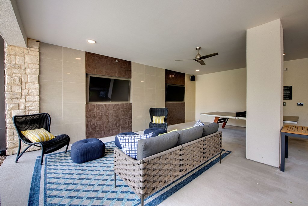 a living room with a couch and chairs and a stone wall