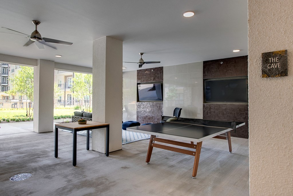 a game room with a ping pong table and a television