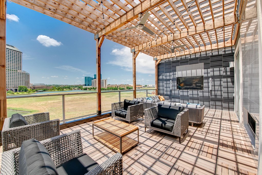 a patio with chairs and a pergola and a view of the city
