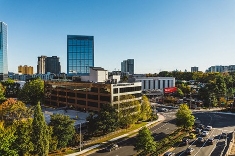 an aerial view of a city with a building and a parking lot