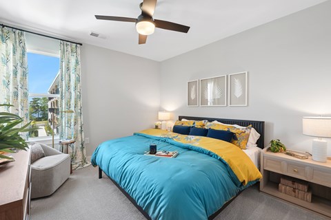 A bedroom with a blue bedspread and yellow pillows.