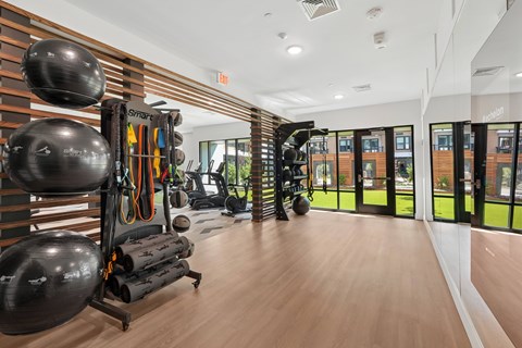 A gym with a variety of equipment including a treadmill, a rowing machine, and a weight bench.