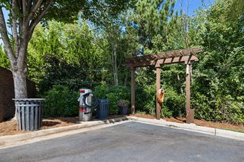 A tree-lined street with a wooden pergola and a fire hydrant.