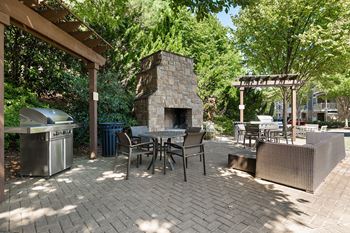 A patio with a table, chairs, and a fireplace.