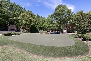A park with a green lawn and trees.