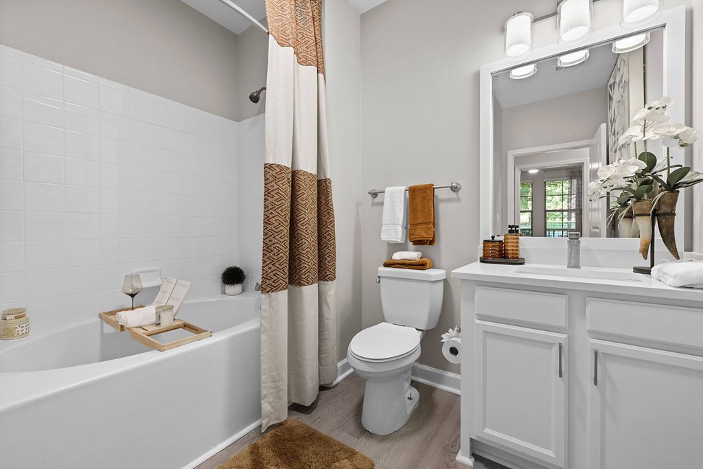 A white bathroom with a toilet, sink, and tub.