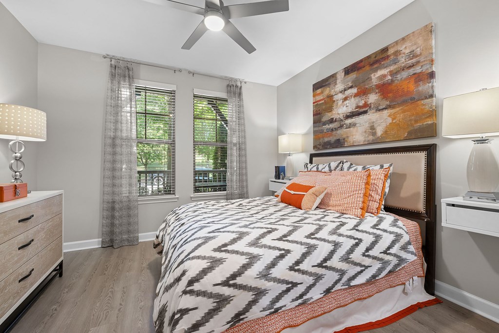 A bedroom with a large bed and a ceiling fan.