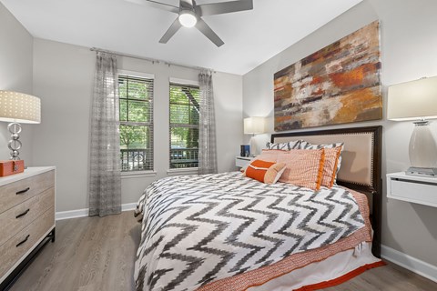 A bedroom with a large bed and a ceiling fan.