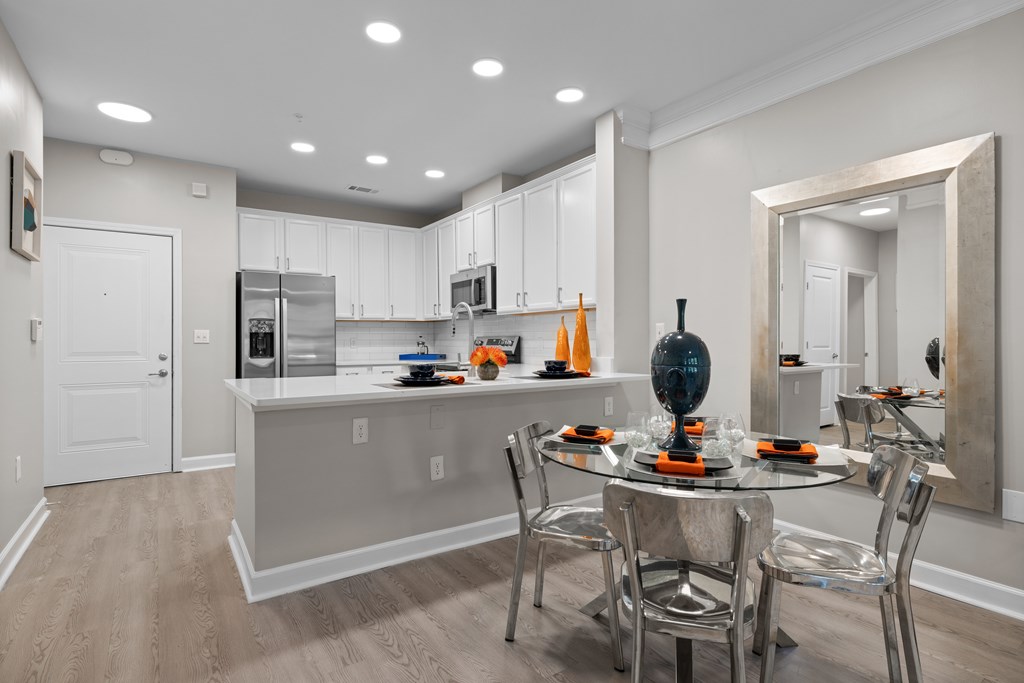 A modern kitchen with a dining table set for two.
