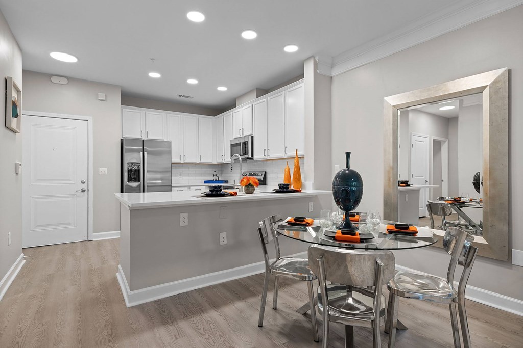 A modern kitchen with a dining table set for two.