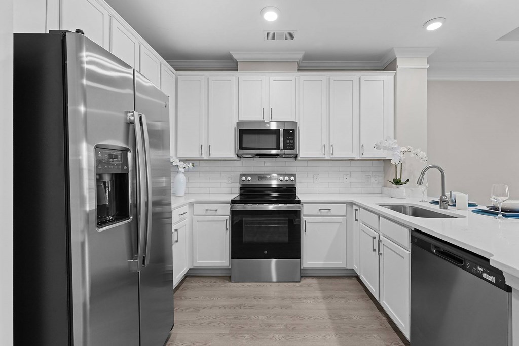 A modern kitchen with stainless steel appliances and white cabinets.