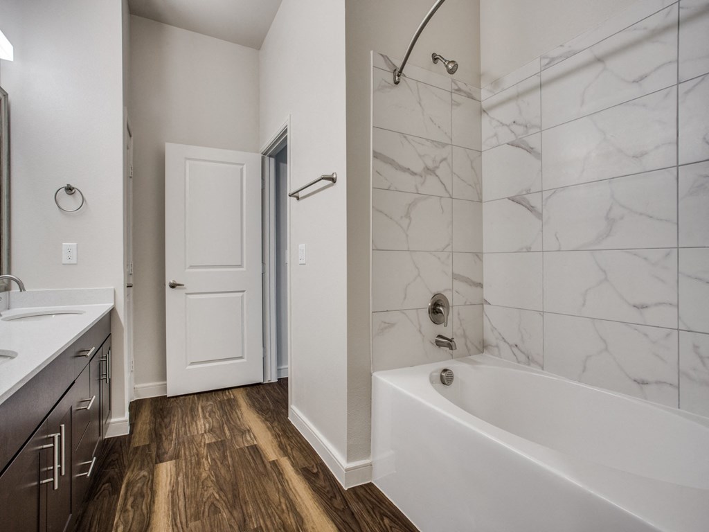 a bathroom with a tub and a shower and a sink