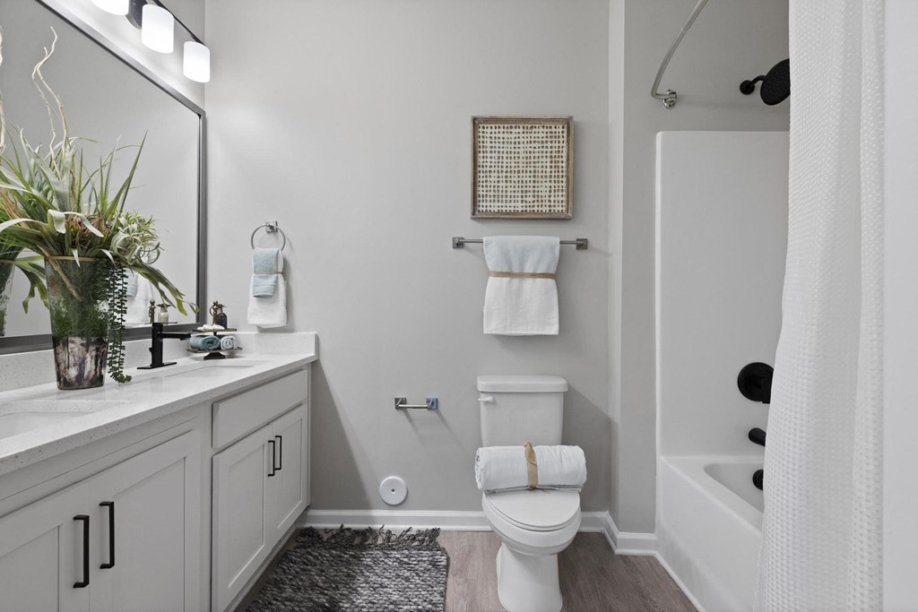 a white bathroom with a white toilet and a tub and a sink