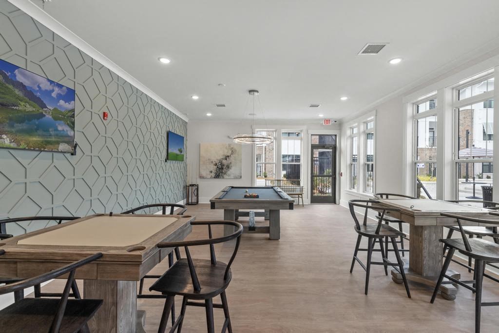 a room with tables and chairs and a pool table