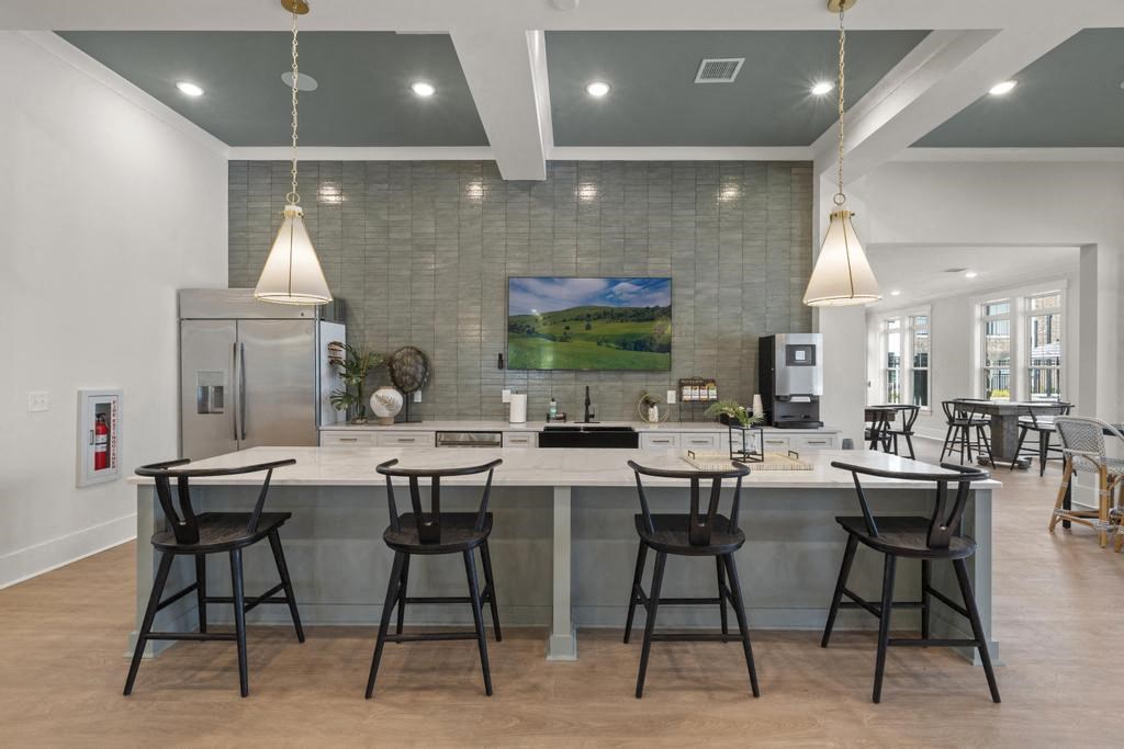 a large kitchen with a counter and bar chairs