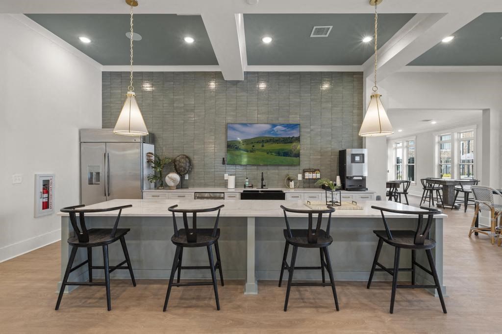 a large kitchen with a counter and bar chairs