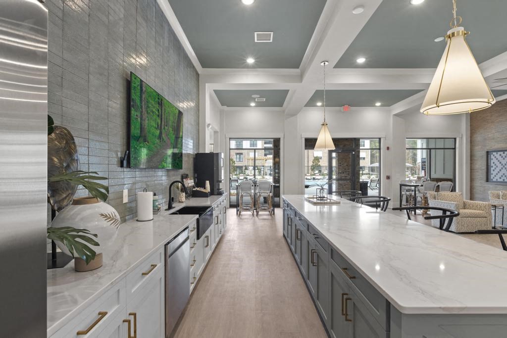 a large kitchen with white counter tops and a large window
