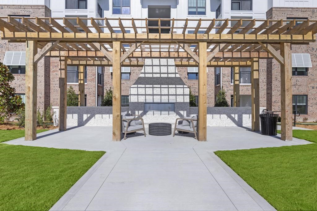 a pavilion with a table and chairs in front of a building
