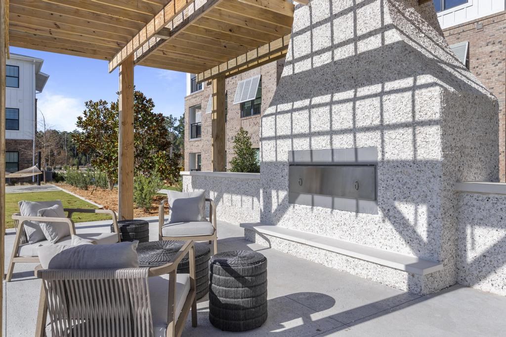 a patio with chairs and a fire pit