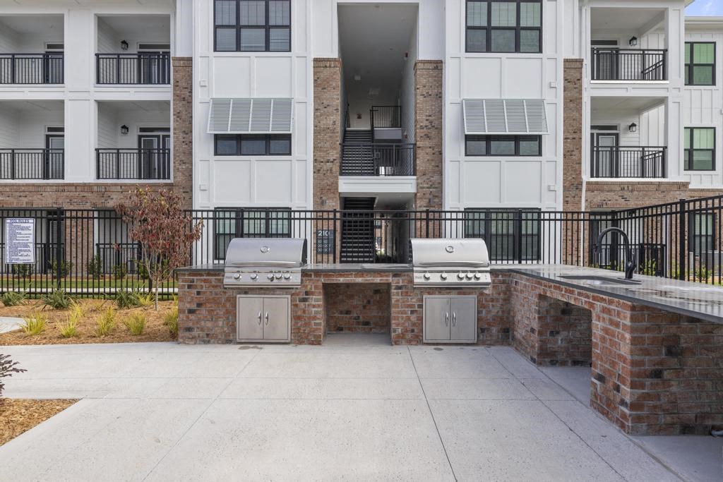 two bbq pits in front of an apartment building