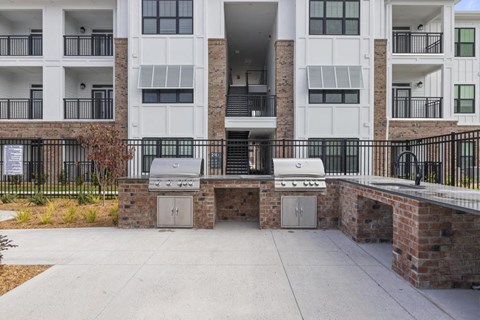 two bbq pits in front of an apartment building