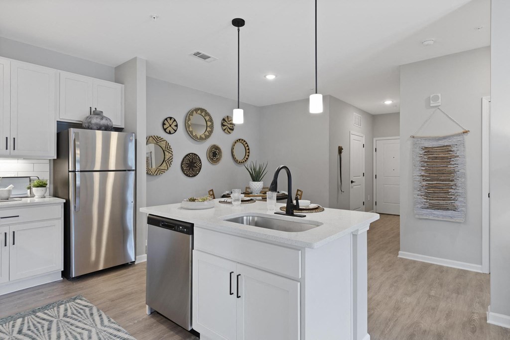 an open kitchen and living room with a stainless steel refrigerator