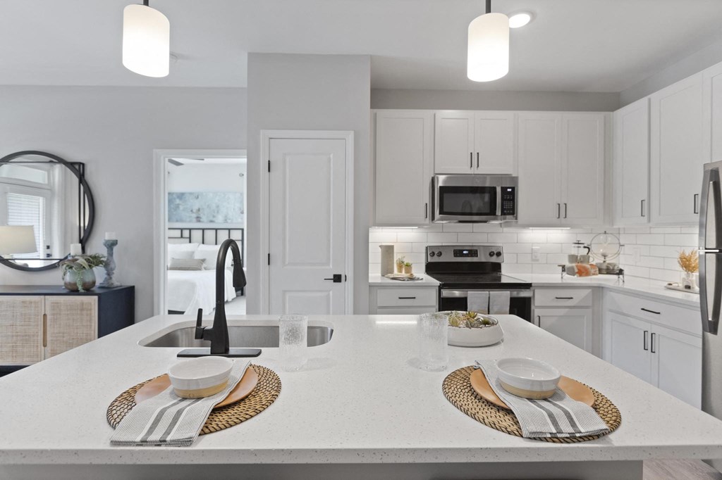 an open kitchen with white cabinets and white counter tops