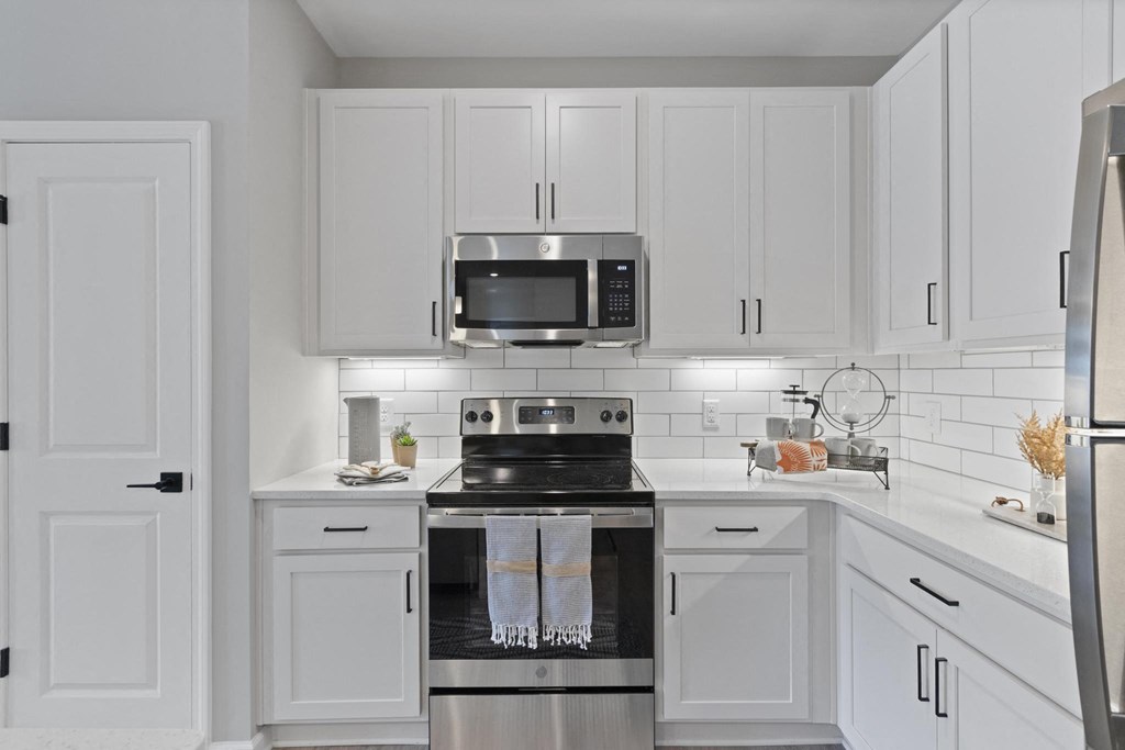 a white kitchen with a stove and a microwave