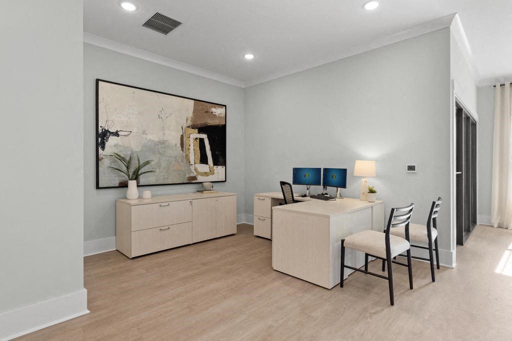 a home office with a desk and chairs and a large painting