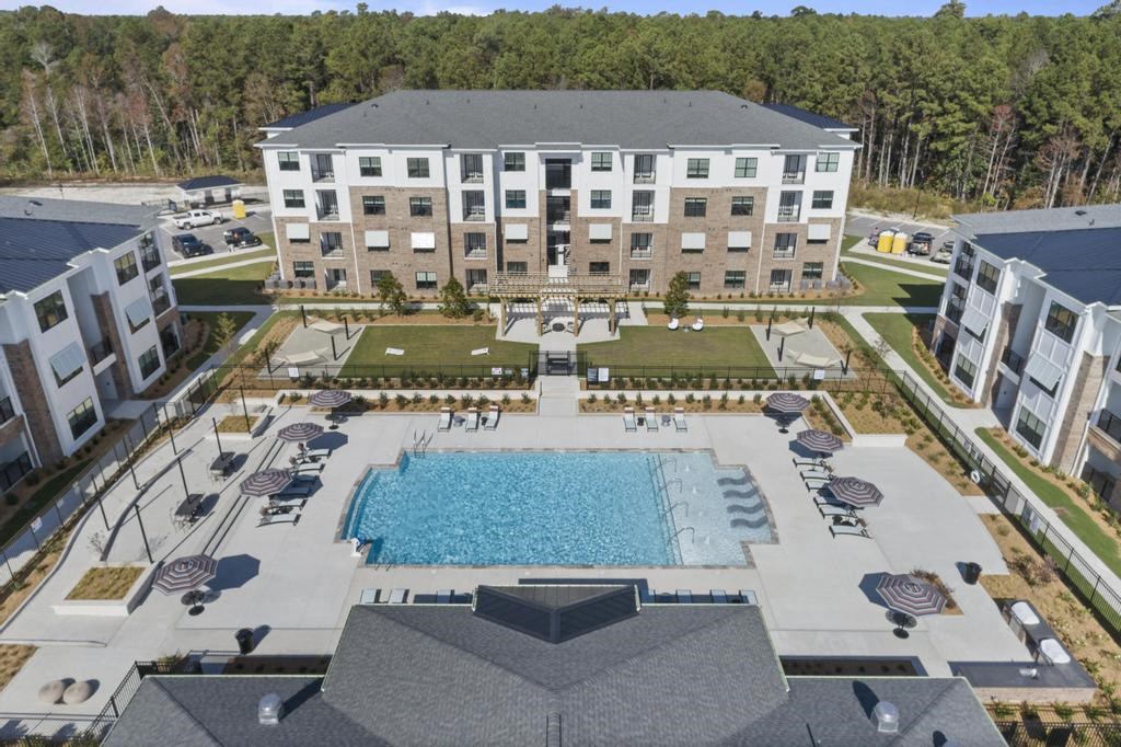 an aerial view of an apartment building and an outdoor pool