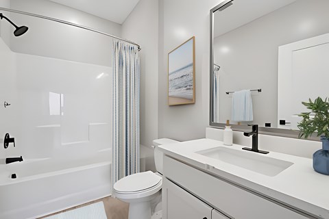 A white bathroom with a toilet, sink, and shower.