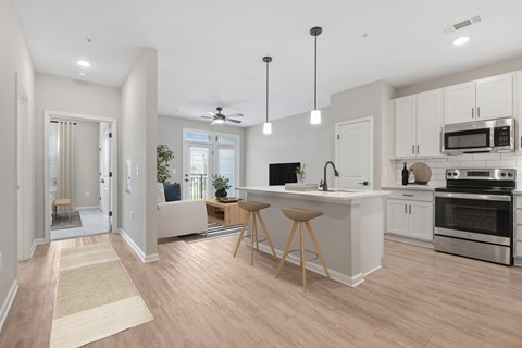 A modern kitchen with a dining area and a living room.