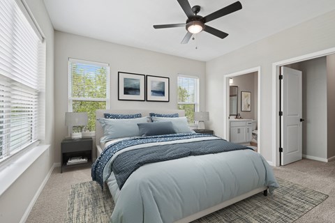 A bedroom with a large bed and a ceiling fan.