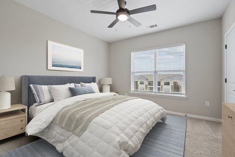 A bedroom with a large bed and a ceiling fan.