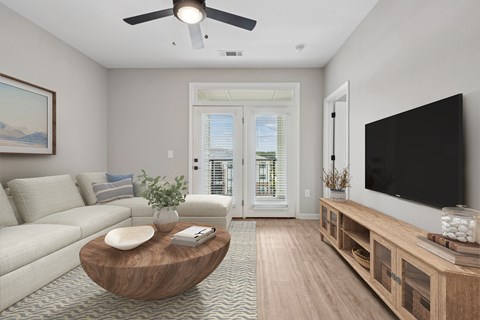 A living room with a white couch, a coffee table, a flat screen TV, and a painting on the wall.
