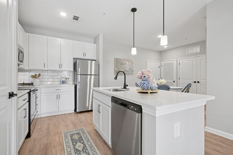 A kitchen with white cabinets and a large island.