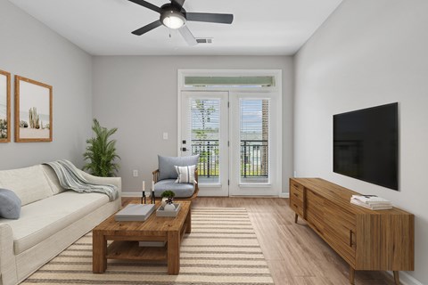 A living room with a couch, a coffee table, a television, and a plant.