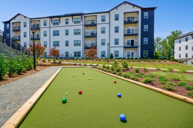 A bocce ball course with green grass and red and blue balls.