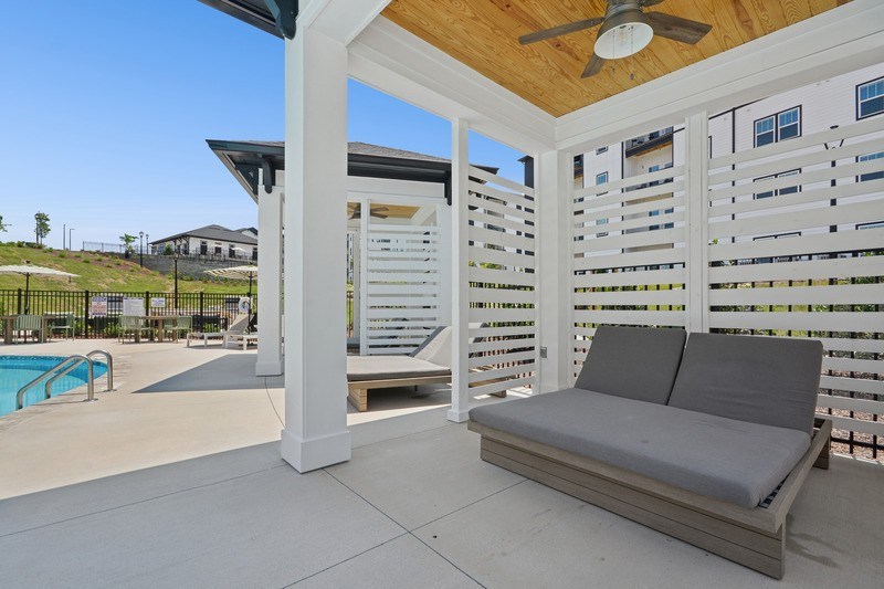 A patio with a sofa and a pool.
