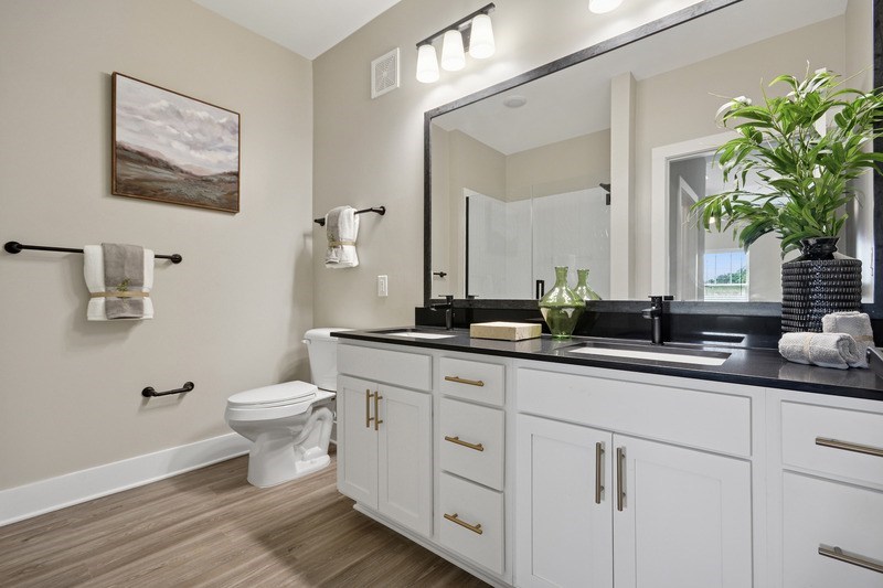 A bathroom with a toilet, sink, and a mirror.