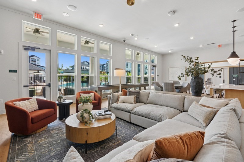A living room with a red chair and a grey couch.