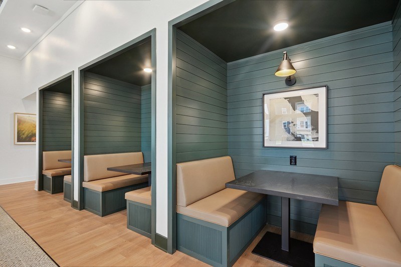 A room with grey tables and beige chairs.