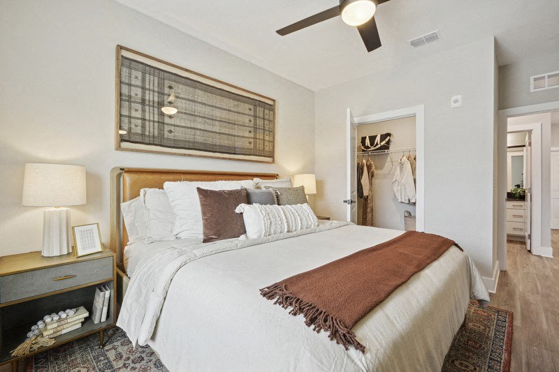 A bedroom with a large bed and a ceiling fan.