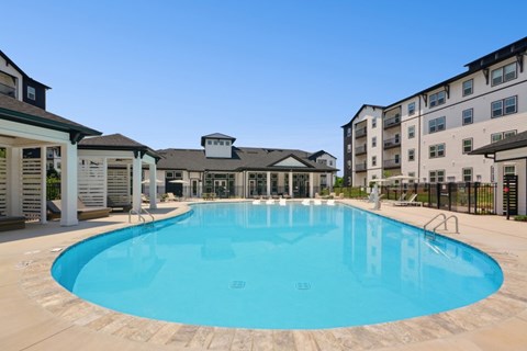 A large outdoor swimming pool surrounded by apartment buildings.