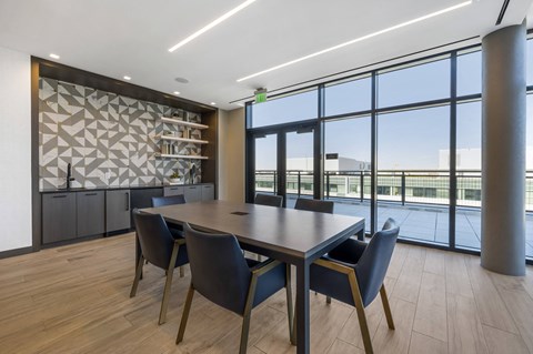 a meeting room with large windows and a wooden table with blue chairs