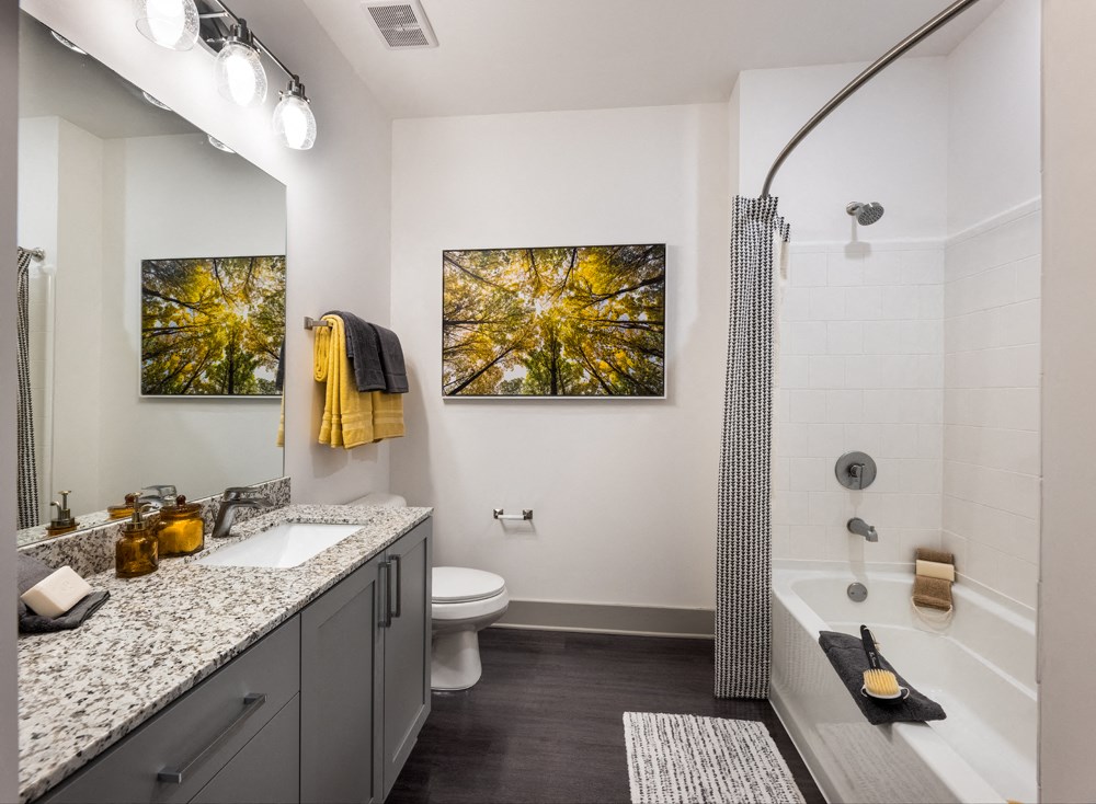 A bathroom with a white toilet, sink, and shower.