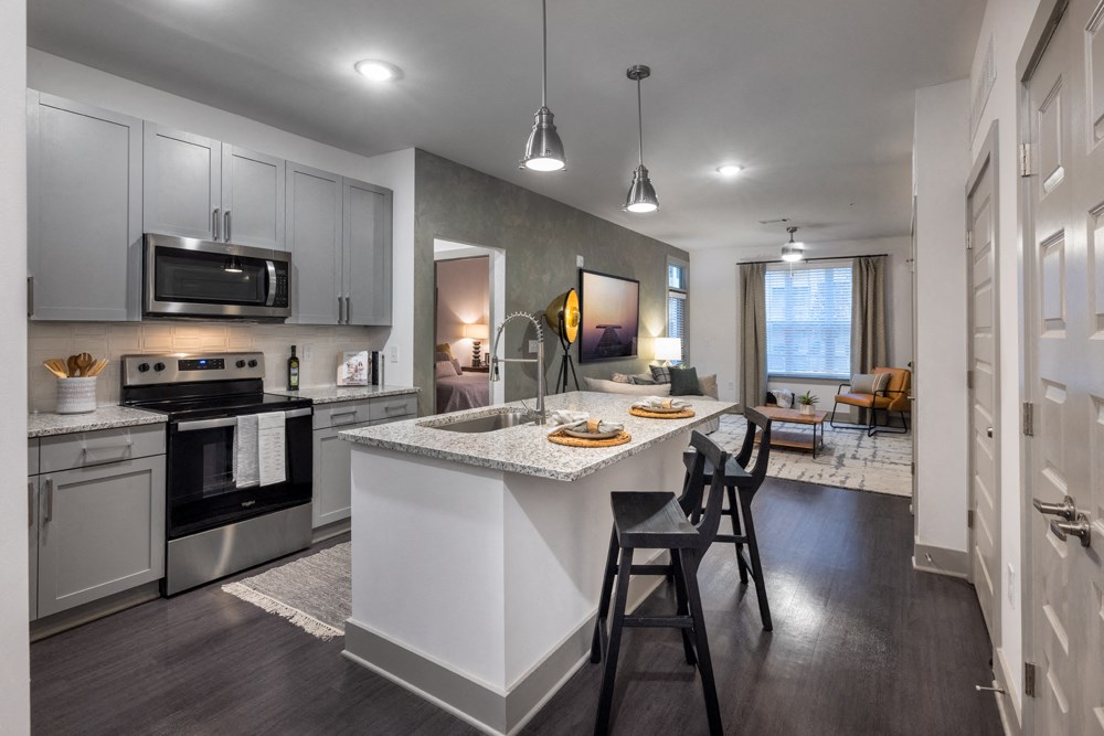 A modern kitchen with a large island and bar stools.